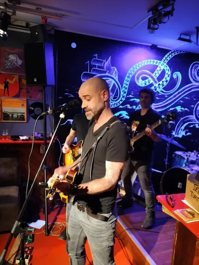 Chanteur et guitariste en concert live, lumière bleue