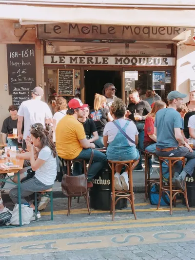 Clients en discussion sur la terrasse devant le bar