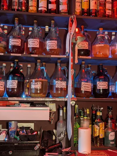Étagères du bar, bonbonnes de rhum arrangé et parfums