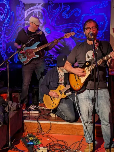 Trio de musiciens, basse et guitares sur scène